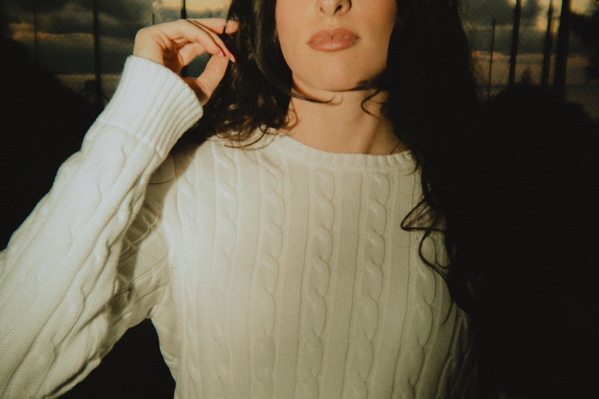 cable knit sweater rolled linen trousers barefoot wooden dock closeup