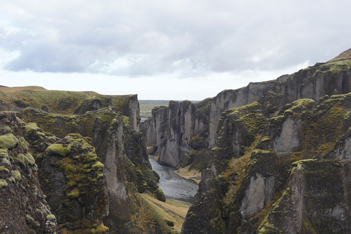 Fjadrargljufur canyon Iceland green mossy walls river winding dramatic aerial view