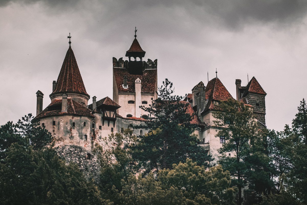 Bran Castle Romania Transylvania dark forest morning mist dramatic sky