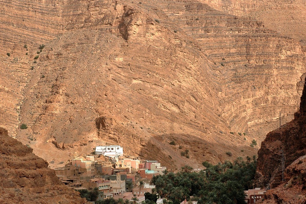 Atlas Mountains Morocco fog-filled valley with snow-capped peaks and Berber village at dawn
