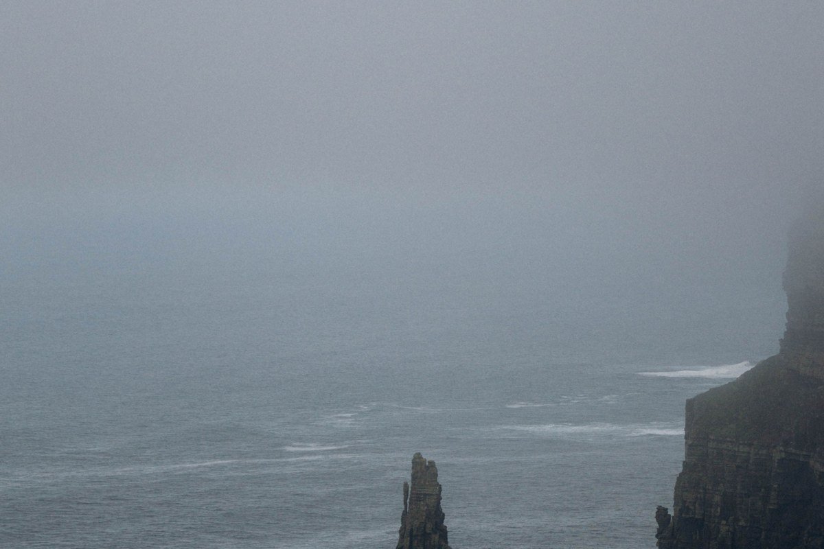 Trollkonufingur sea stack Faroe Islands moody fog rocky ocean pillar