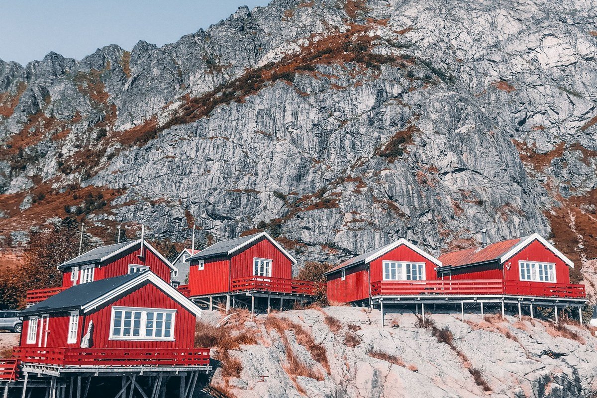 Norway fjord village moody fog wooden houses reflected in still water at dawn