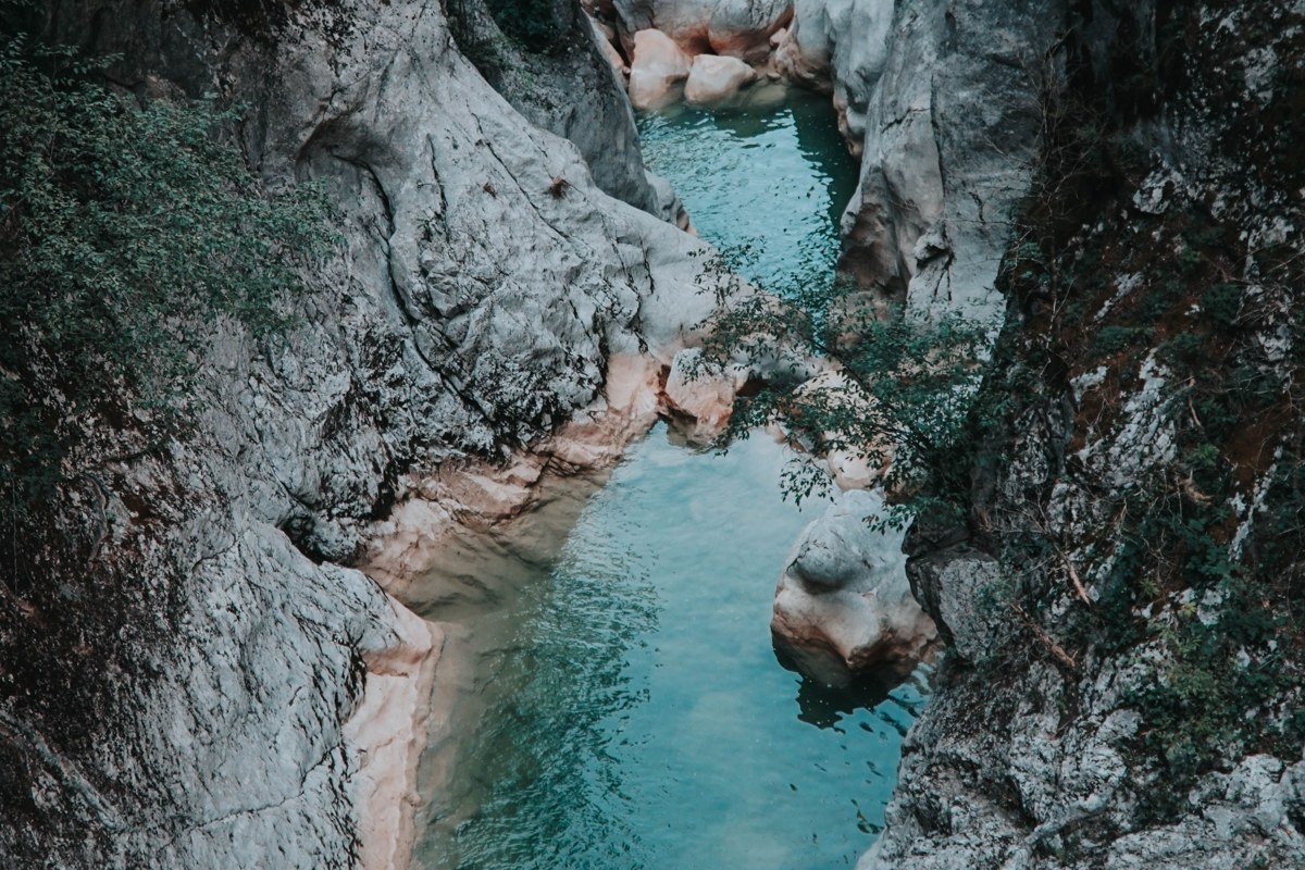 Zagori Greece stone arched bridge over turquoise river gorge surrounded by dense forest mountains
