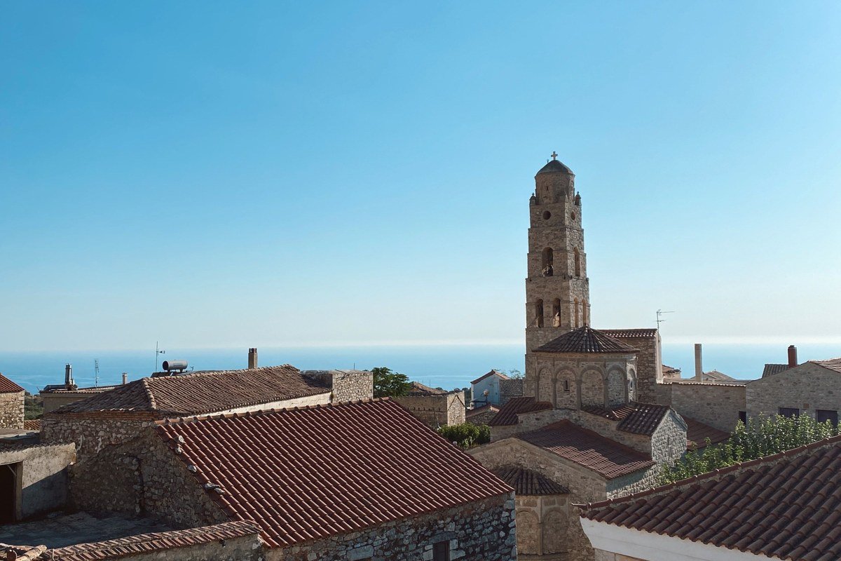 Mani Peninsula Greece stone tower houses village on barren rocky landscape with deep blue sea horizon