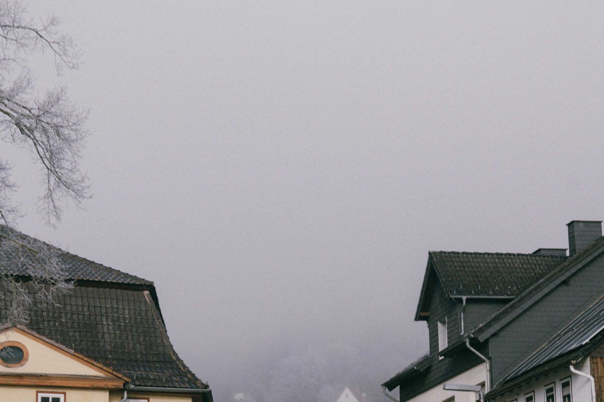 misty medieval European village cobblestone street fog morning golden hour