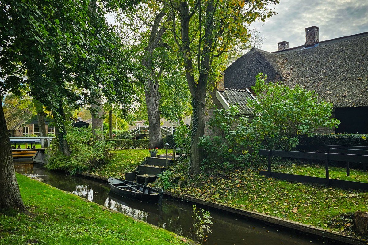 Giethoorn Netherlands thatched roof cottage canal punting boat misty morning
