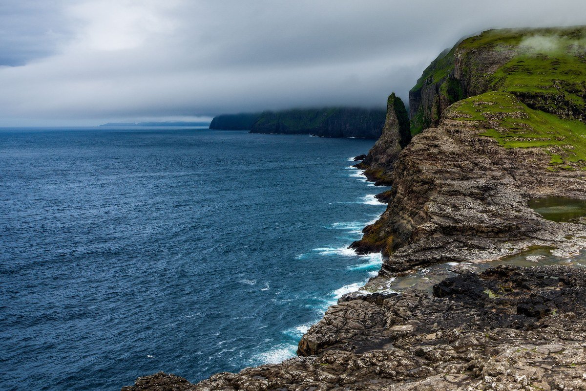 Gasadalur Faroe Islands waterfall village cliffs Atlantic ocean aerial misty