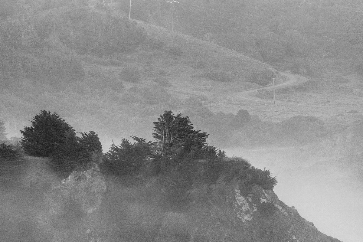 Mendocino headlands in September fog, white-painted water towers and Victorian cottages visible above the sea cliffs