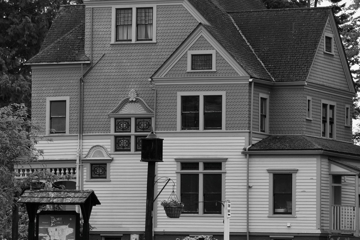 Port Townsend's Victorian waterfront along Water Street, Puget Sound visible behind the brick storefronts on an overcast autumn morning