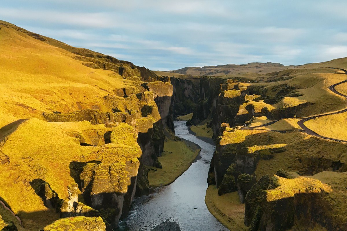 dramatic African wilderness landscape with red cliffs river gorge and golden savanna aerial view