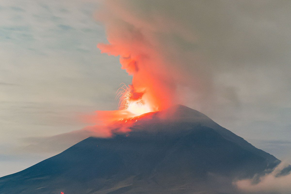 Erta Ale Ethiopia lava lake glowing orange crater edge night volcanic smoke