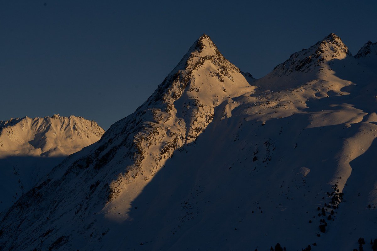 sharp winter geometry of snow-covered Three Sisters ridgeline at golden hour, Glencoe Valley Scotland