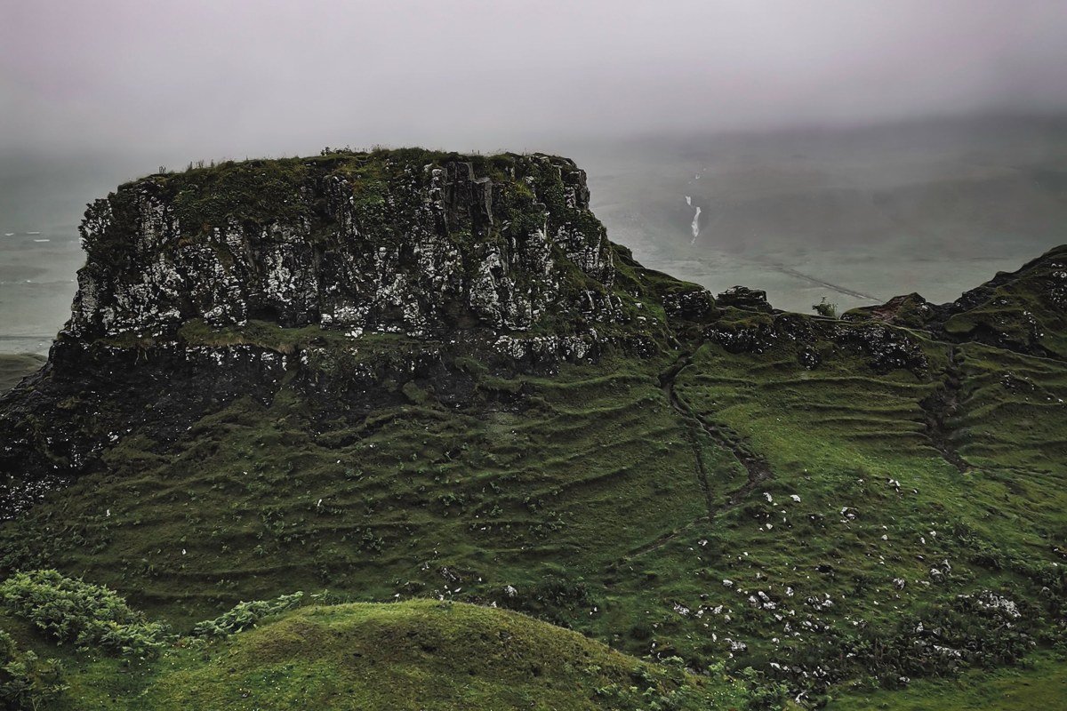 moody autumn fog dissolving around needle pinnacles and tilted turf shelves, Quiraing Isle of Skye Scotland