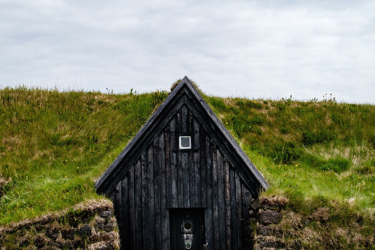 Iceland remote turf roof village harbor fog mountains dramatic sky