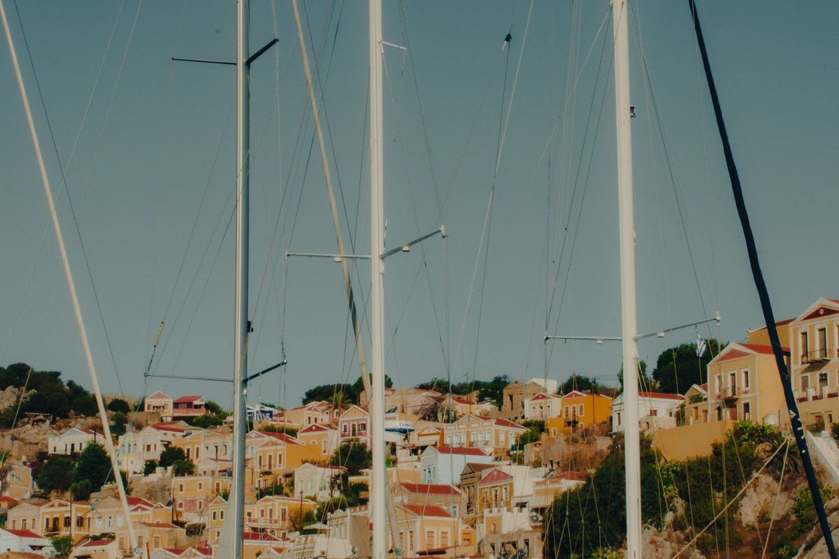 Halki island Greece neoclassical pastel waterfront mansions harbor reflection calm water
