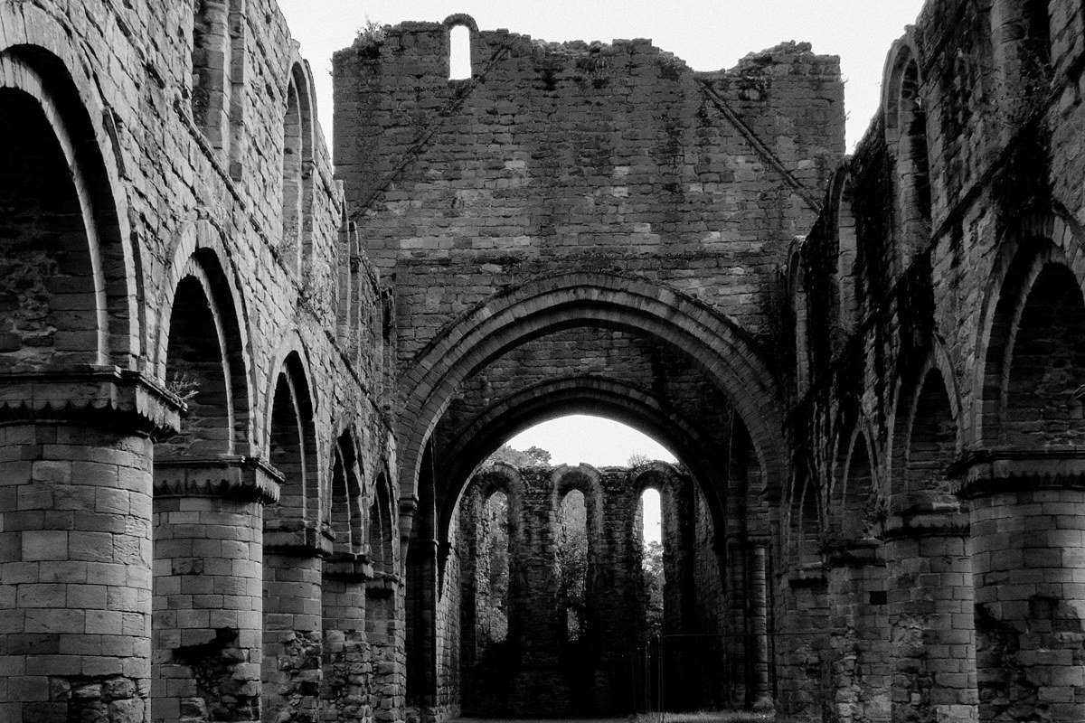 Dryburgh Abbey Scottish Borders ruins arched stone doorway misty trees romantic light