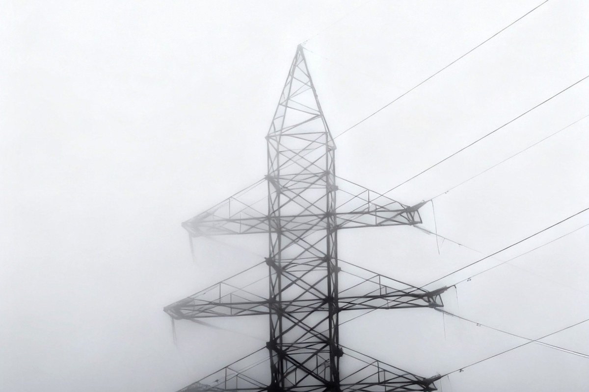 A zip-line rider crossing a steel cable above the cloud forest canopy near Arenal, the volcano's grey cone visible through a break in the mist, vultures circling at the same altitude in the background