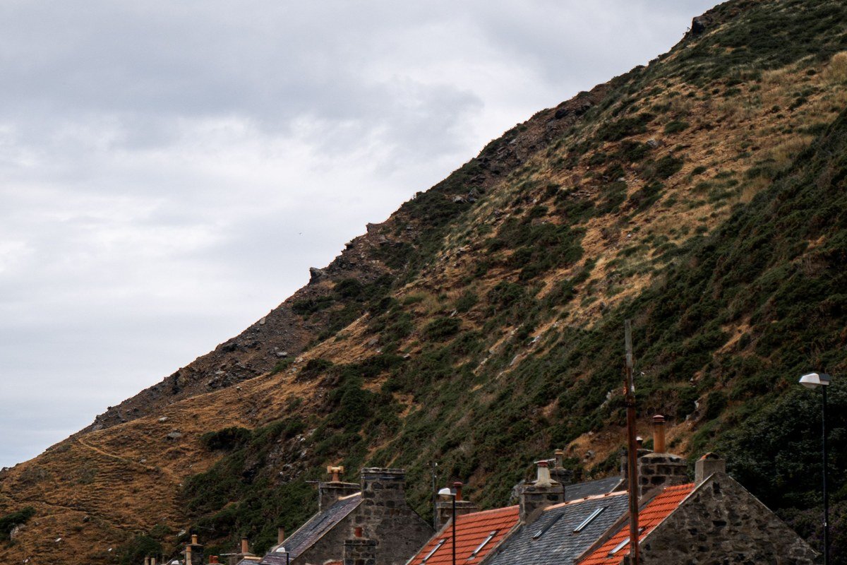 Crovie Aberdeenshire tiny row fisherman cottages storm sea cliffs aerial