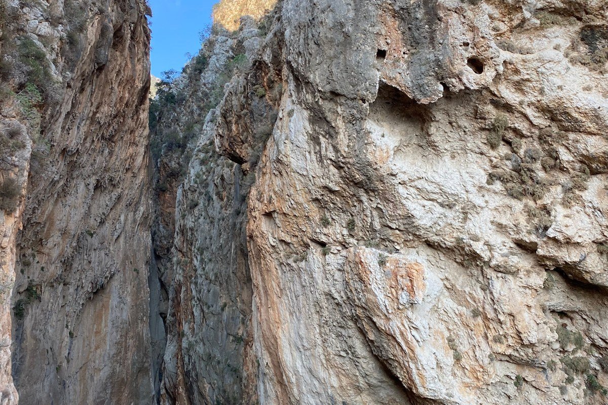 Aradena Gorge Crete narrow limestone canyon trekker sunlight shaft