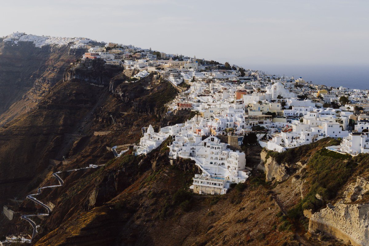 aerial view turquoise Greek island coastline whitewashed village cliffs Mediterranean