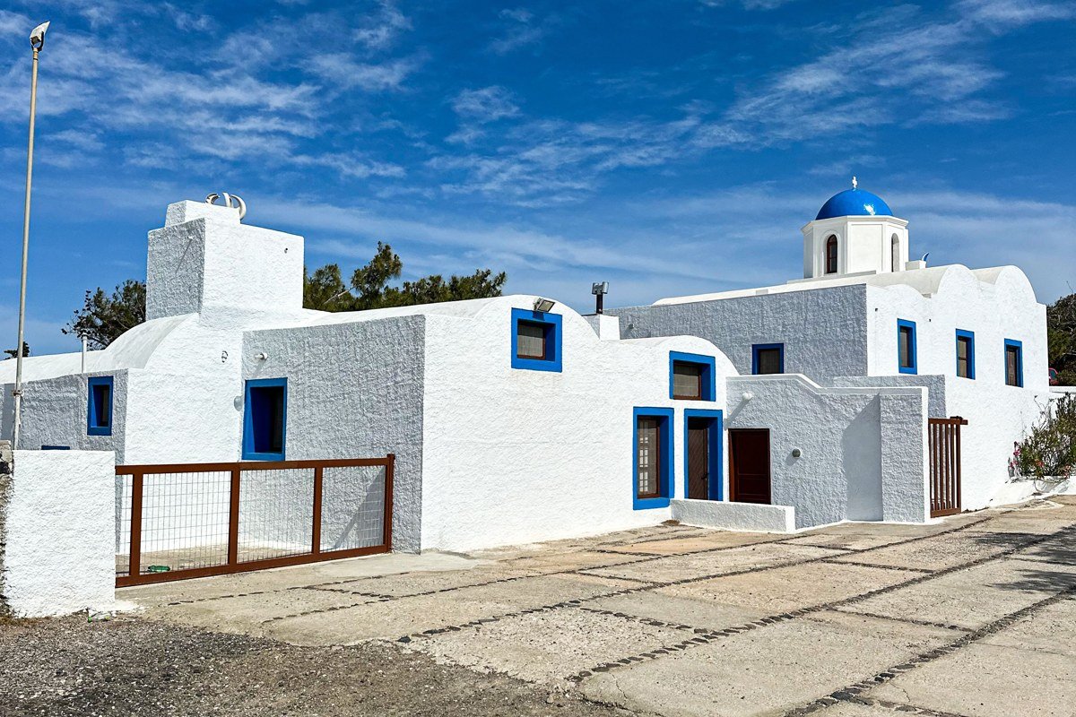 Nisyros Mandraki village black volcanic rock white church bright colors Greece