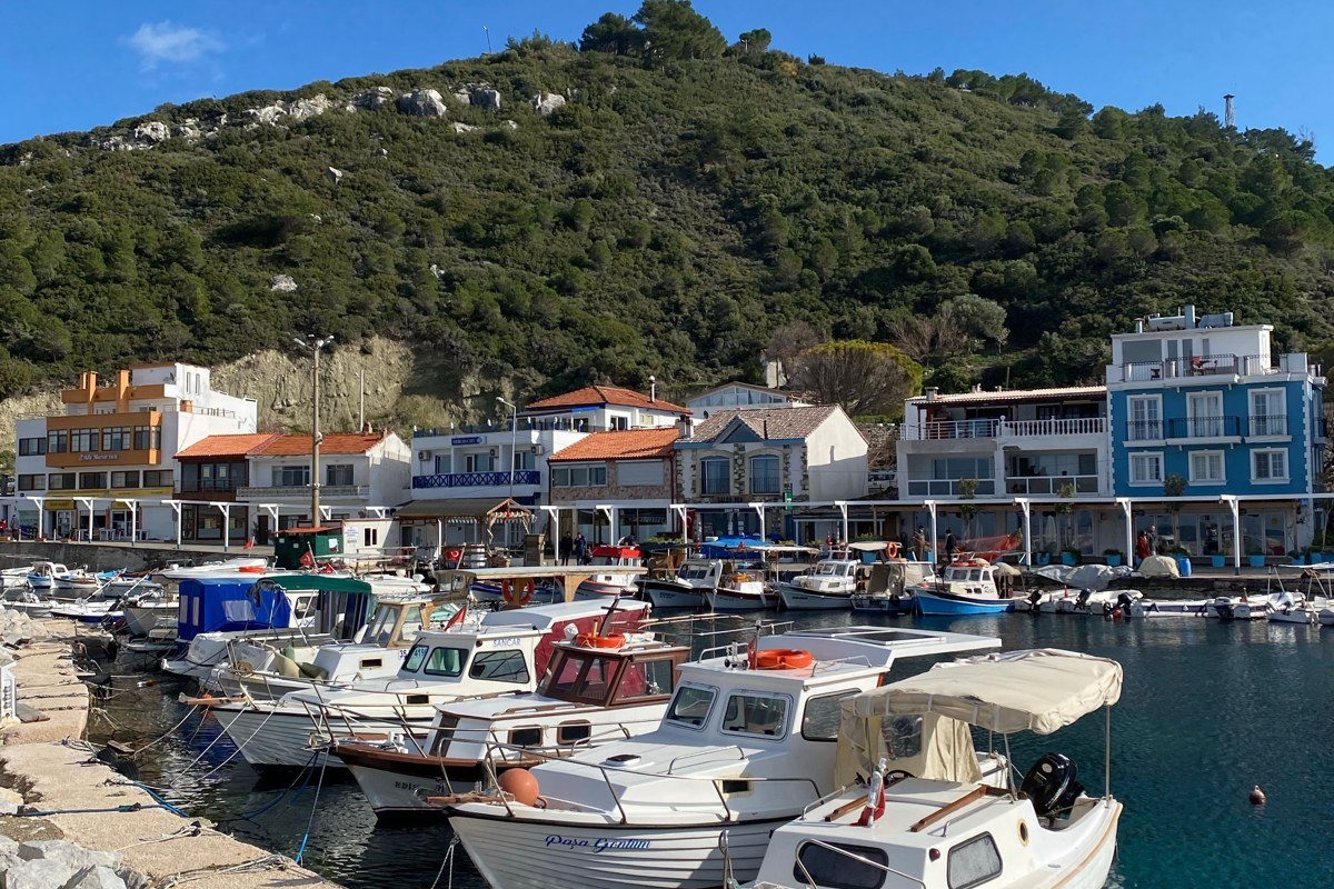 Ikaria Greece terraced hillside village stone houses blue Aegean coastline fishing boats