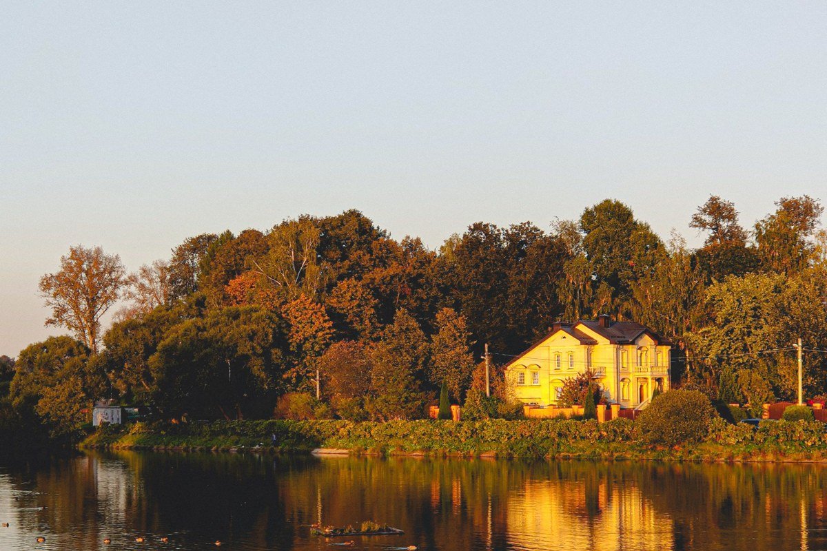 golden dusk reflection of Creole storefronts on Cane River Lake, Natchitoches, Louisiana, warm string lights on brick