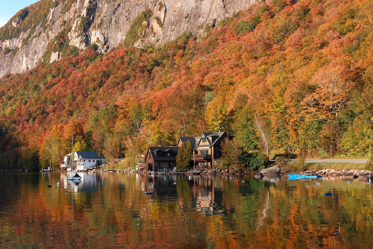 Lake Placid New York mirror lake shoreline with Adirondack chairs and autumn foliage