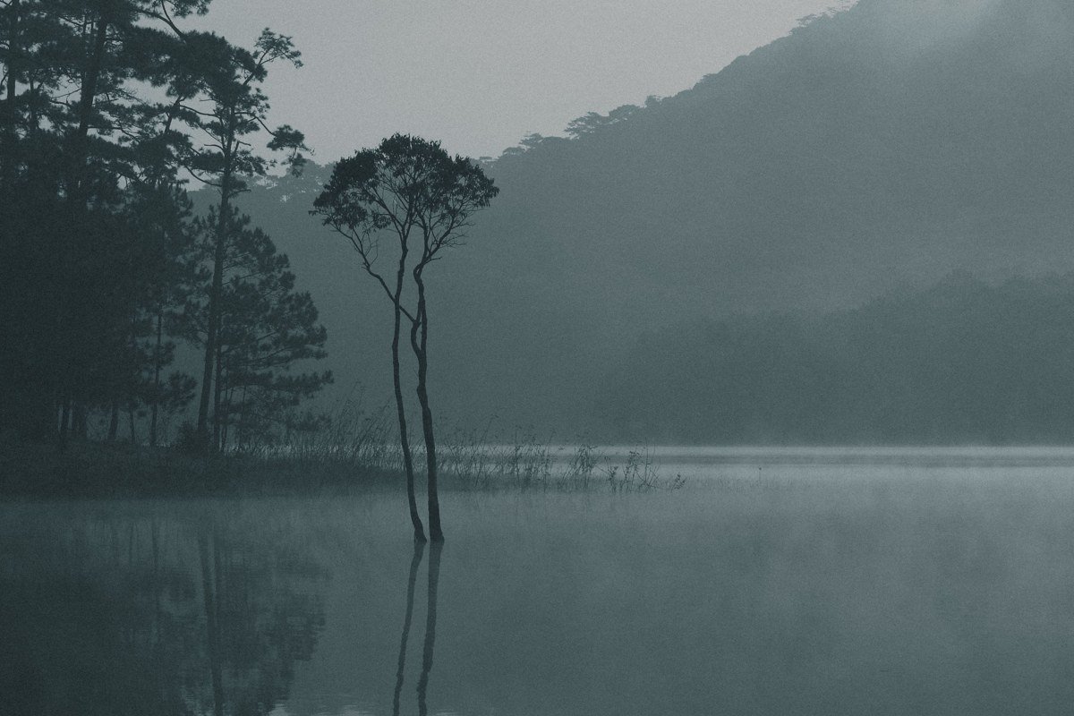 Glendalough monastic ruins Ireland misty morning with round tower and lake reflection