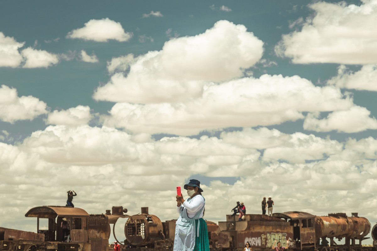 Uyuni Bolivia train cemetery rusted locomotives desert dusk sky orange