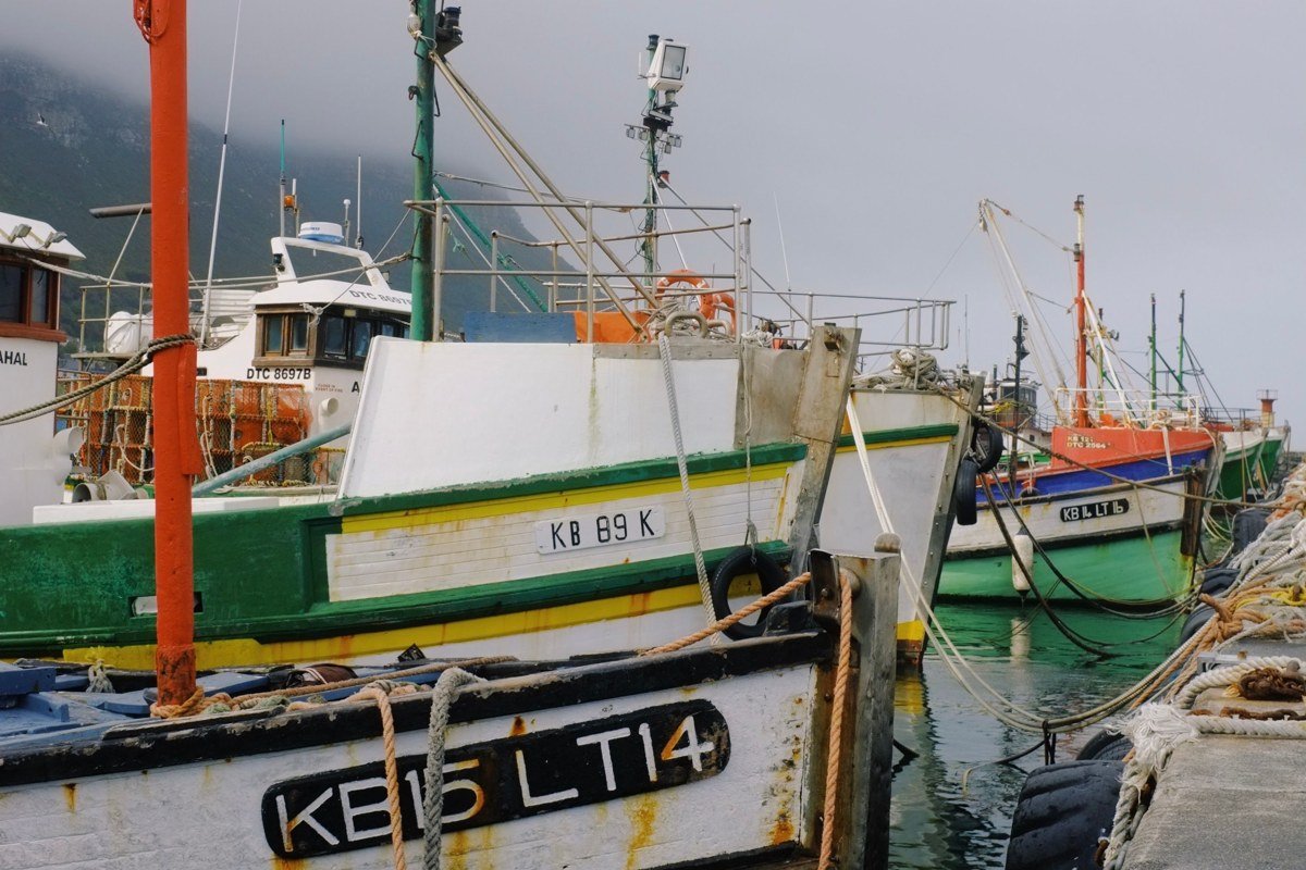 fishing boats in fog at the harbor in Copper Harbor Michigan with pine-covered hills behind