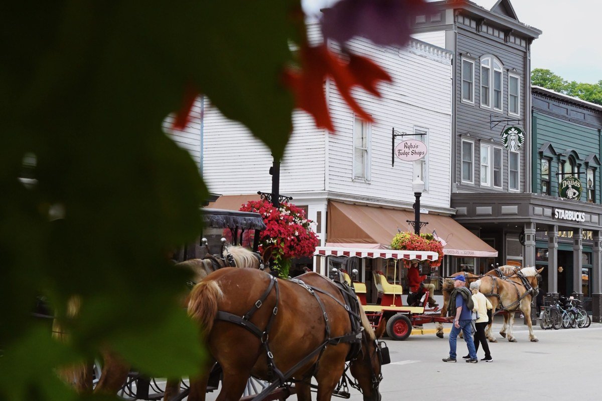 Mackinac Island Michigan horse-drawn carriage on Main Street with Victorian hotel