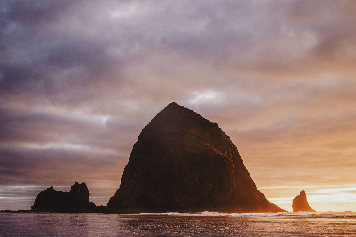 Haystack Rock at Cannon Beach Oregon partially obscured by fog at low tide