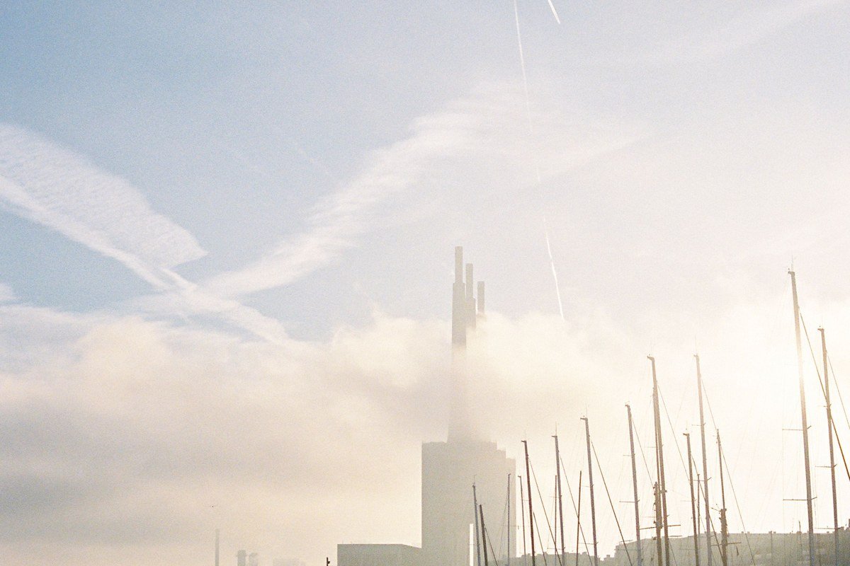 Camden Maine harbor with schooner masts rising through morning fog