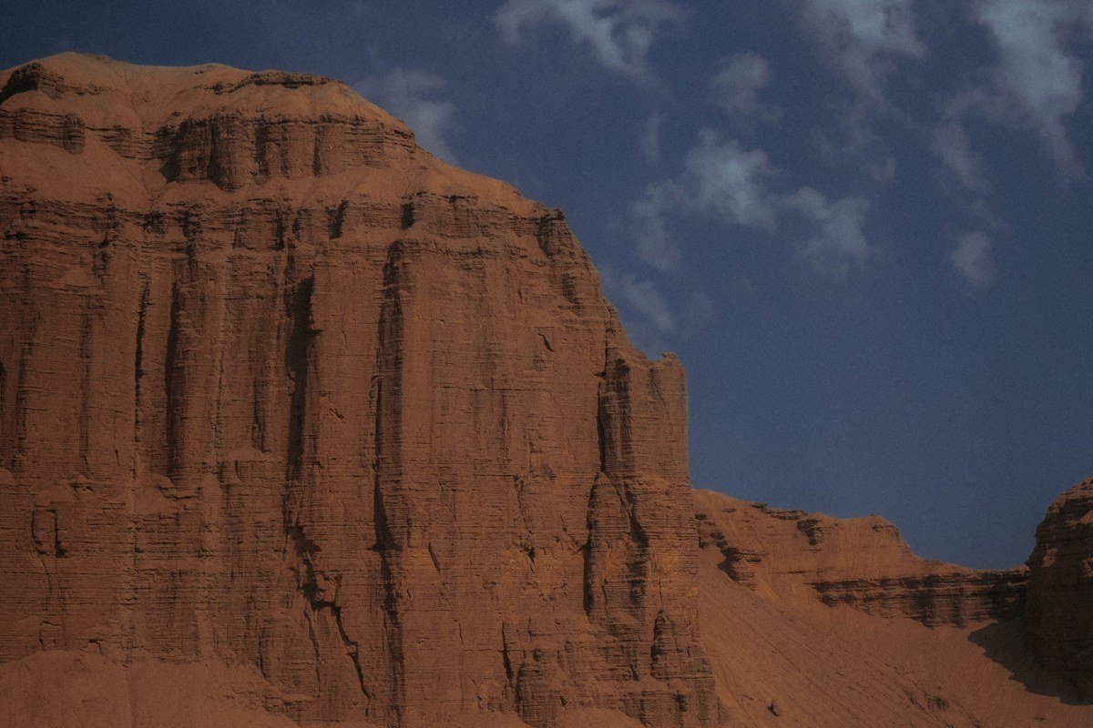Fisher Towers red rock spires catching low morning light, with cottonwood trees along the wash below