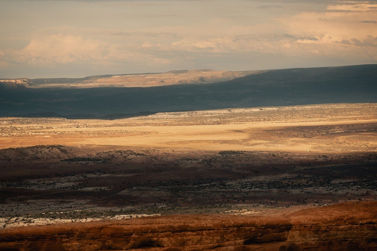 overlook at Island in the Sky, layered canyon walls glowing at golden hour