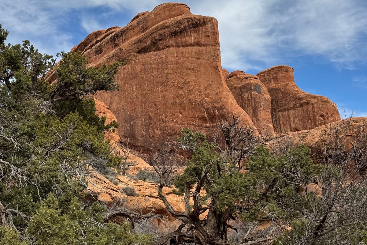 hikers using the cable handline on the slickrock approach to Corona Arch
