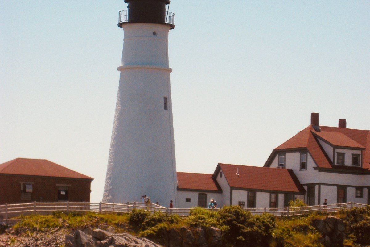 Pemaquid Point Lighthouse Maine fog rolling over striated granite rocks