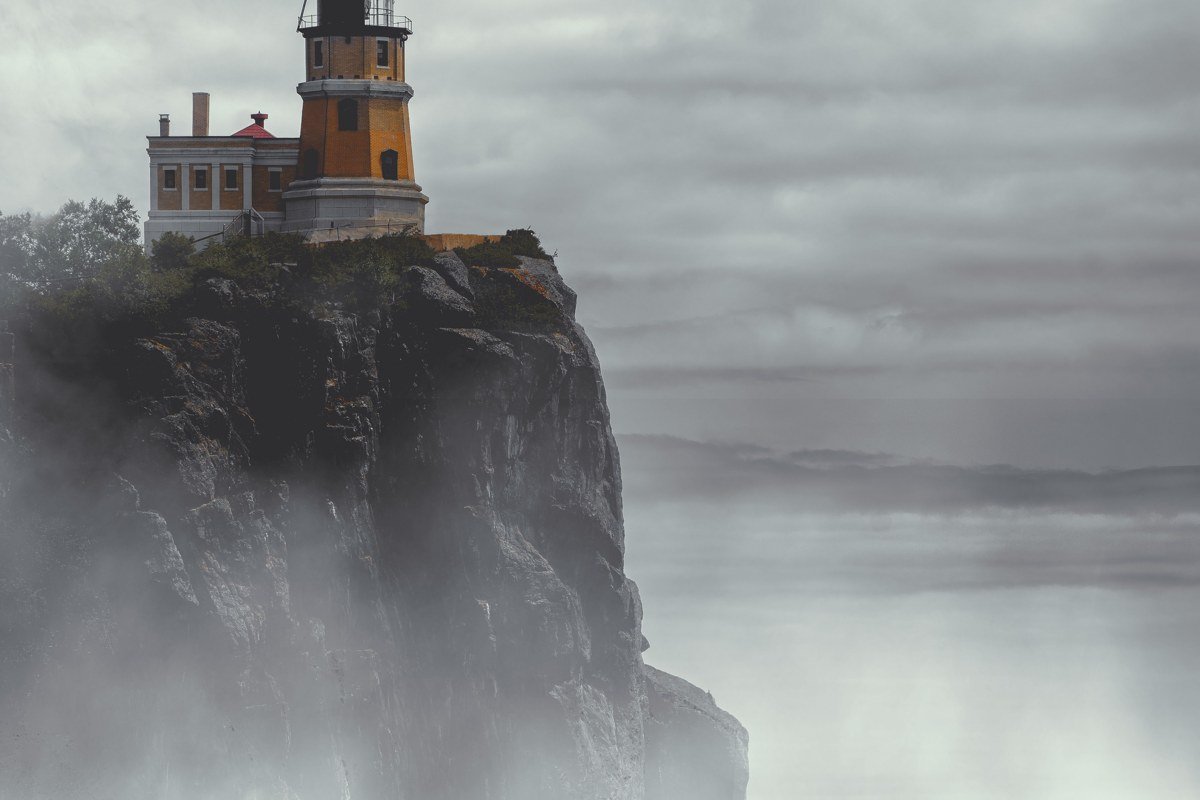 Bass Harbor Head Lighthouse Maine fog and dark spruce trees on rocky cliff