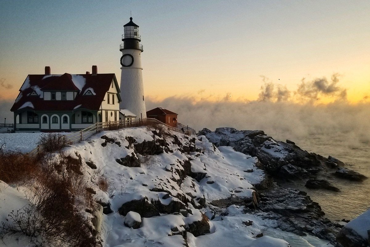 Portland Head Light Maine lighthouse emerging from morning sea fog