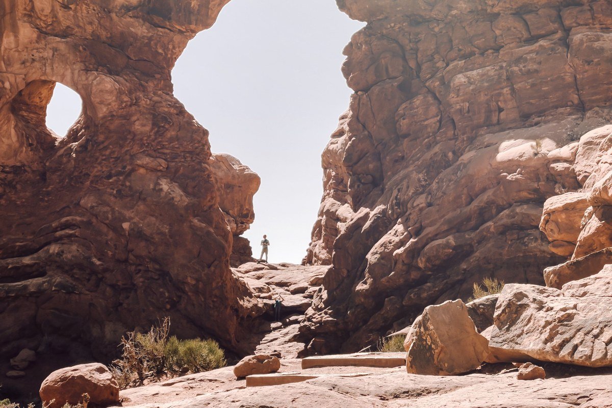 North and South Window arches at sunrise with silhouetted visitors, Arches National Park