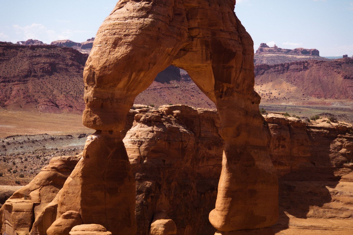 Delicate Arch glowing red at sunset with La Sal Mountains backdrop, Utah