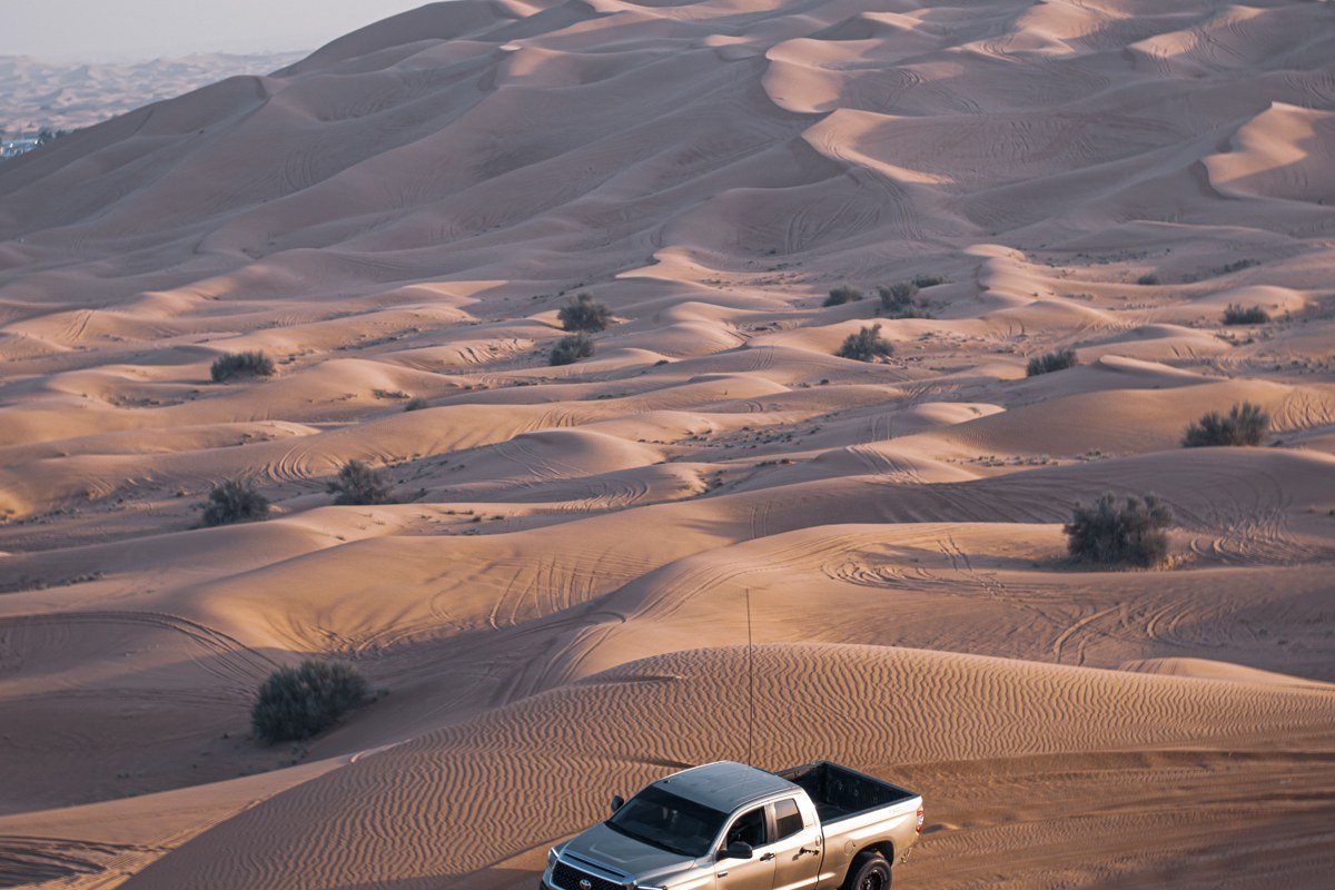 a single pickup truck parked on the dune line of a 16-mile stretch of empty national seashore beach