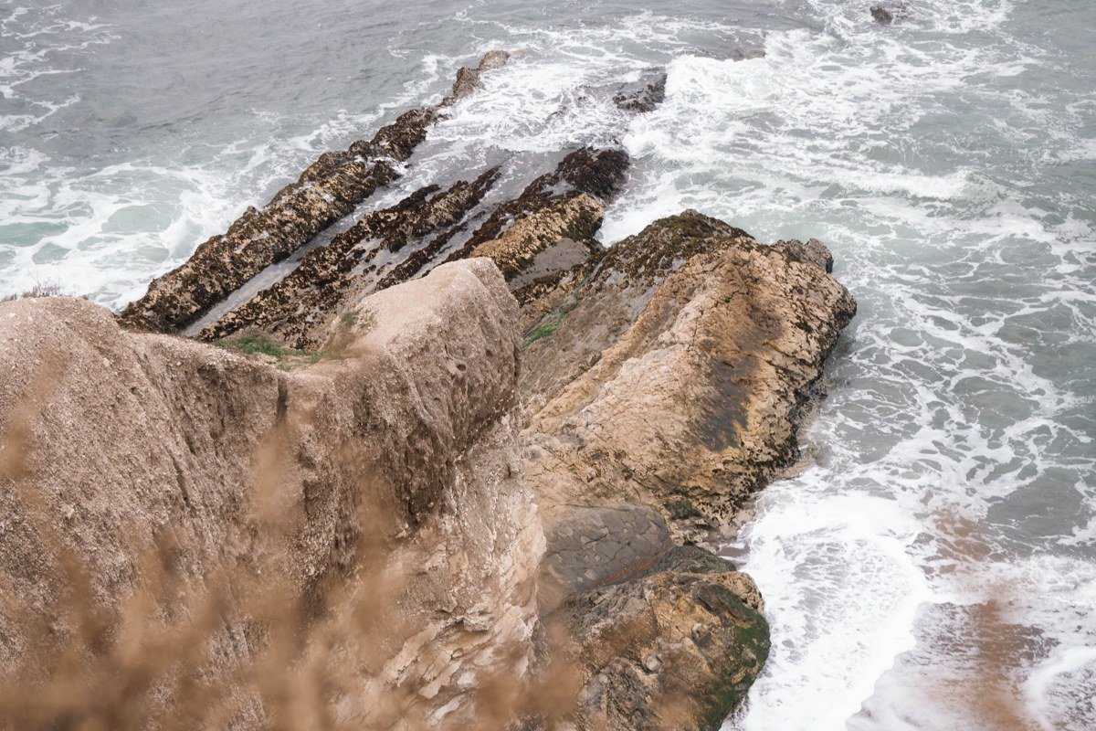 Jade Cove rocky shoreline near Gorda California with fog rolling over the surf