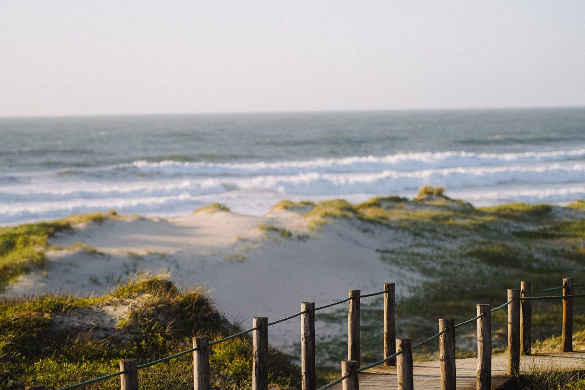 Sandwich boardwalk over marsh grass leading to a Cape Cod Bay beach in fall