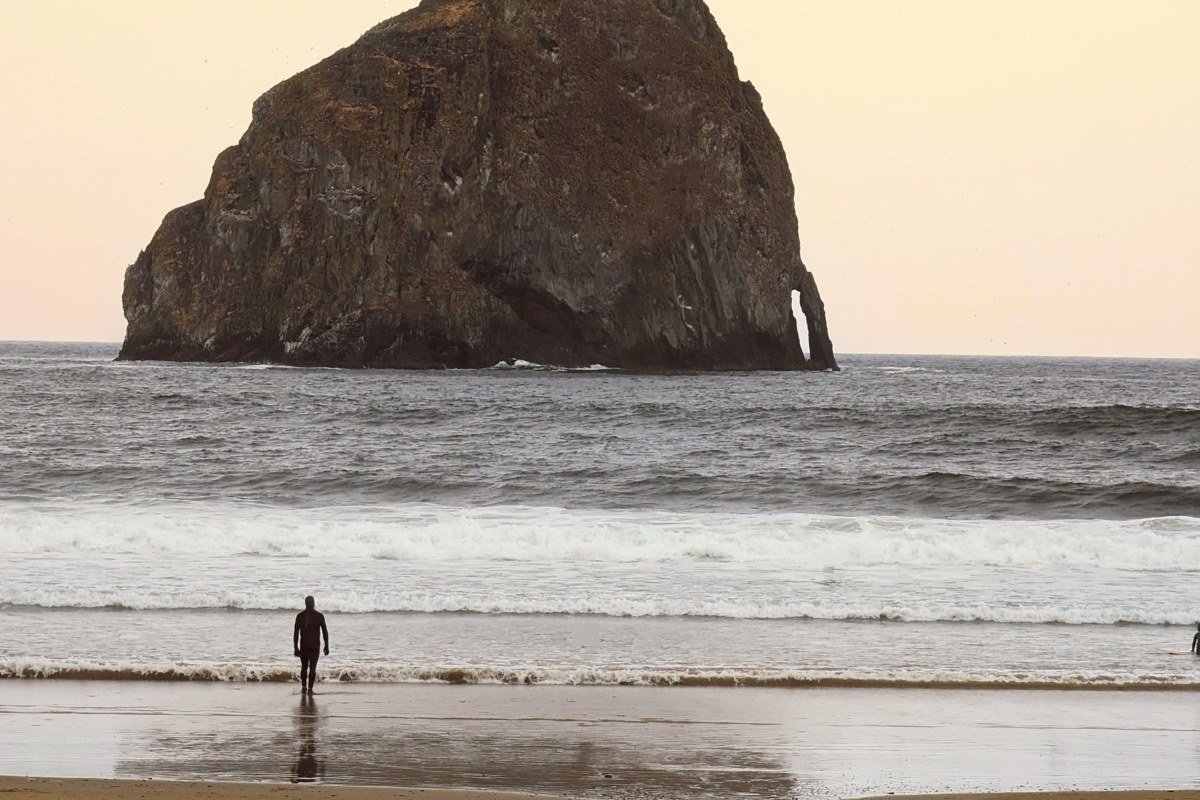 Haystack Rock at Cannon Beach Oregon disappearing into thick coastal fog at low tide