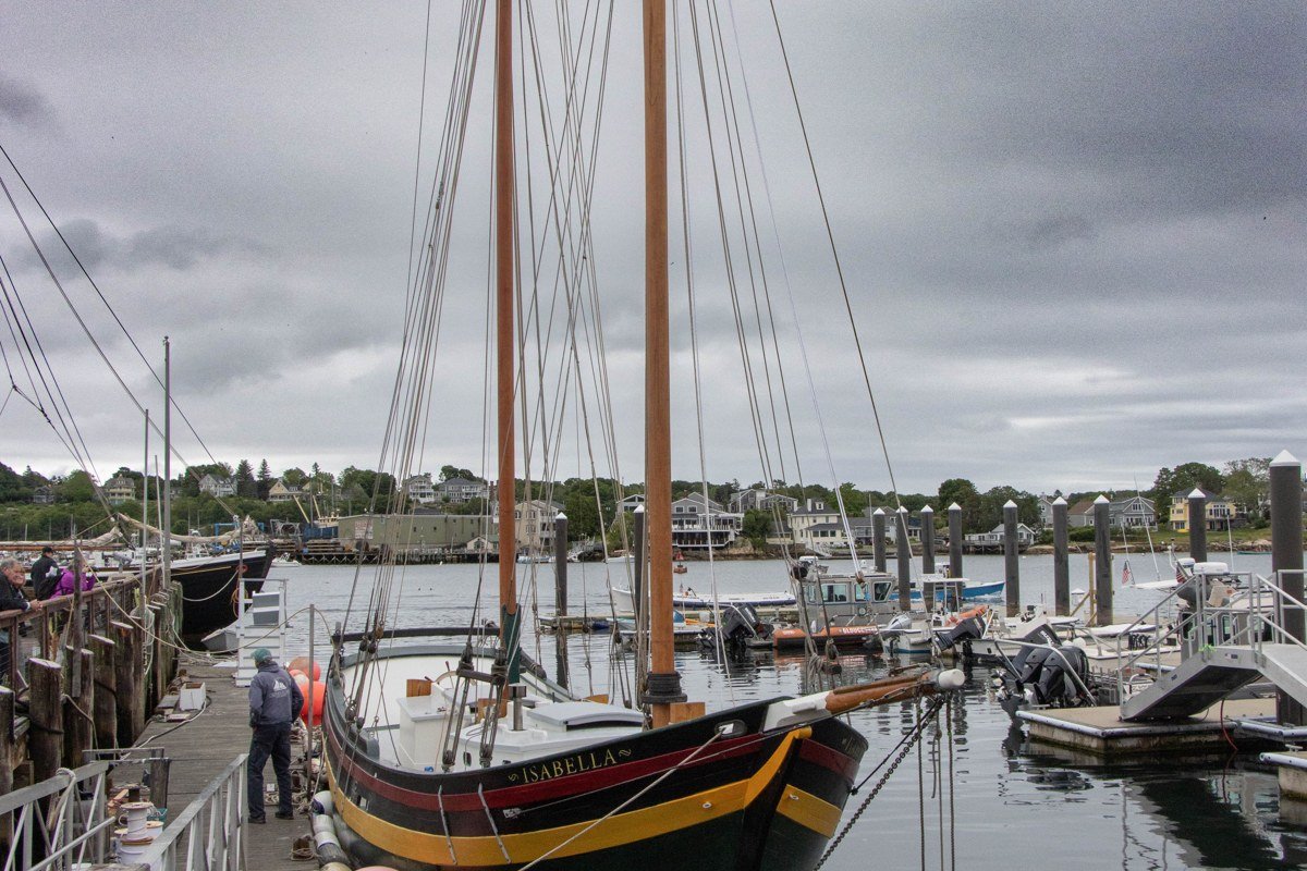 foggy Kennebunkport harbor Maine with white church steeple and moored sailboats
