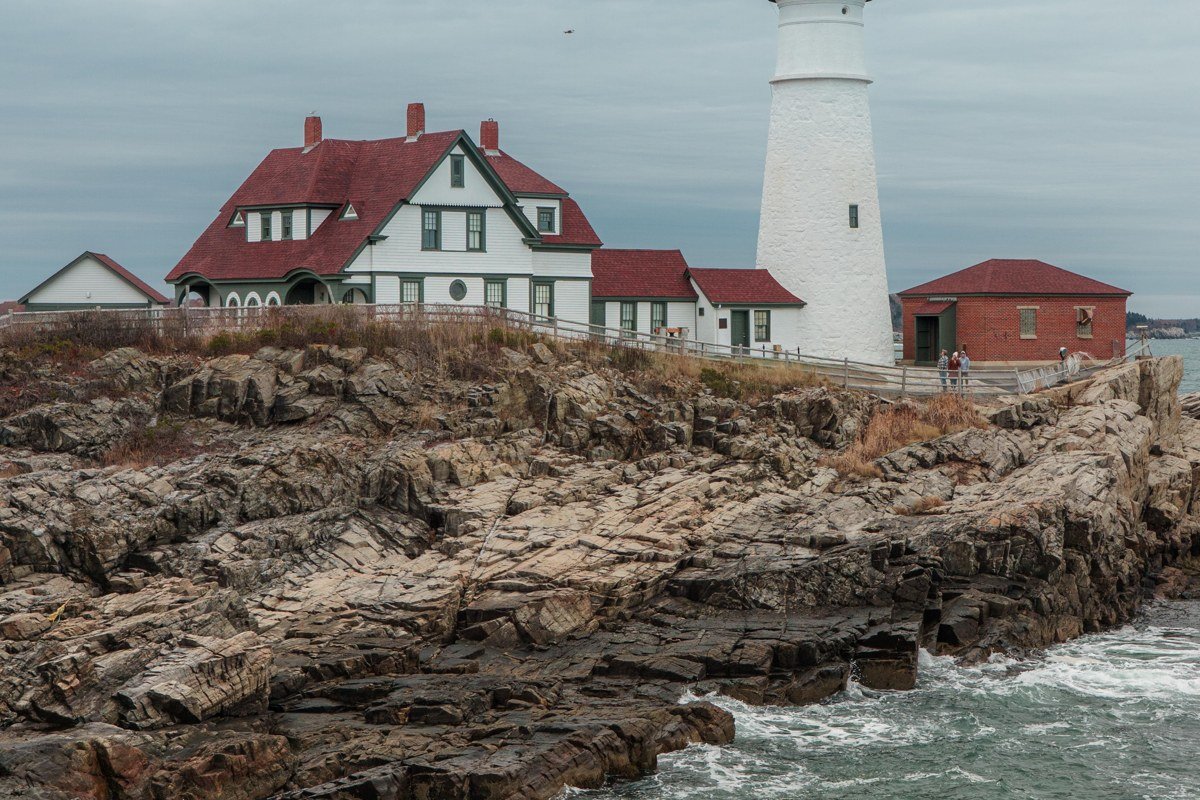 Portland Head Light Maine wrapped in morning fog with waves on rocks