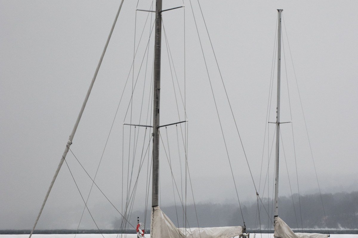 Camden Maine harbor with schooner masts rising through morning fog