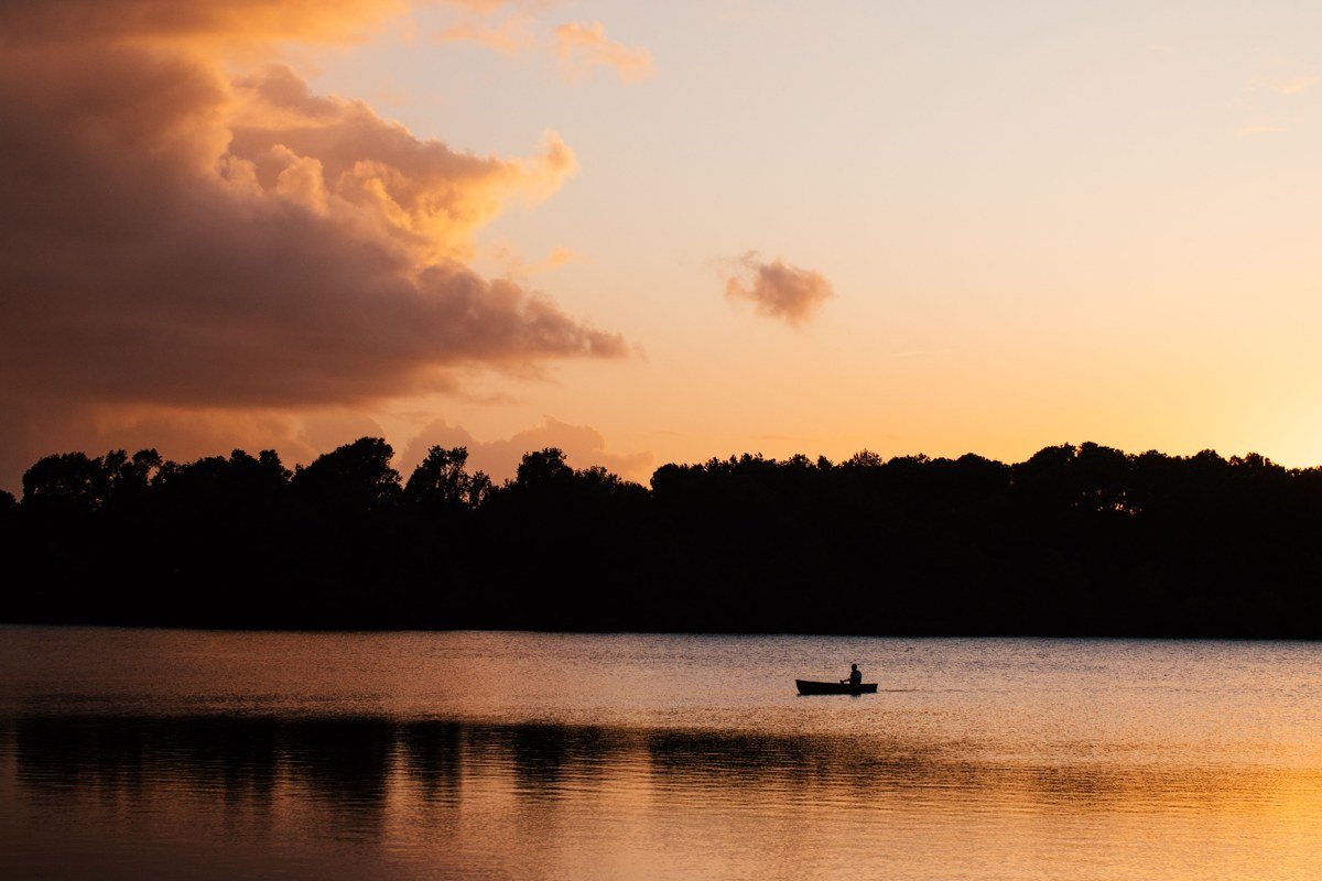 Old Forge on the Fulton Chain of Lakes with canoe on calm water at dusk